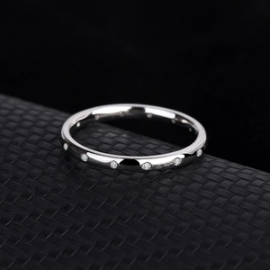 Elegant S925 silver wedding ring with round zircon stones on a black textured stand
