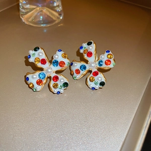 Detail of clover clip-on earrings with white enamel, colorful crystals and pearls