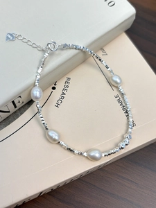 Detailed macro of S925 sterling silver beads and white freshwater pearls on a bracelet