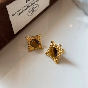 Boucles d'oreilles rétro en œil de tigre ovale avec motif d'étoile dorée sur fond blanc