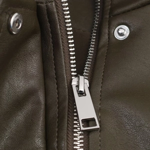 Makro-Detail von Silber-Reißverschluss und Druckknöpfen an dunkelbrauner Kunstlederjacke