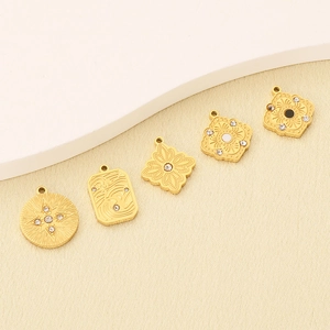Detailed view of five vintage gold stainless steel pendants with micro-inlaid zircon patterns