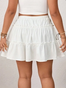 Detail view of white tiered cake skirt showing elastic waistband and cotton texture back