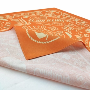 Detail of orange nautical cotton bandana showing stitching and white sea motif prints