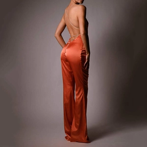 Elegant orange satin backless jumpsuit with fine metallic chain straps and wide leg cut