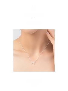 Détail d'un élégant collier nœud en argent S925 porté délicatement sur la clavicule