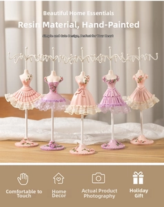 Detail of five resin mannequin jewelry stands with lace dresses and metal hanging hooks