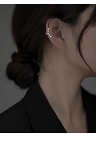 Close-up of elegant 925 silver plated ear cuff with four pearls on a female model