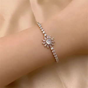 Sparkling zircon sunflower bracelet in gold finish worn by a model on silk background