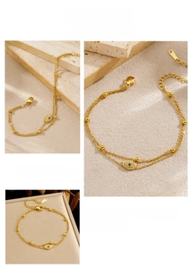 Detail of gold evil eye double chain bracelet with crystal accents and extension chain