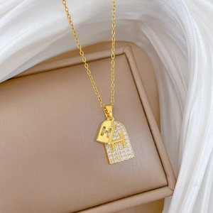 Double-layered gold H-letter zircon necklace for women on elegant beige jewelry box