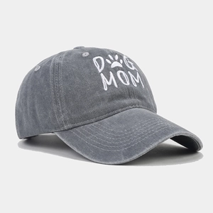 Close-up of Dog Mom embroidery and washed distressed cotton texture on grey baseball cap