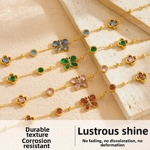 Detailed close-up of gold stainless steel bracelets with colorful butterfly and floral charms