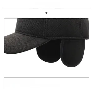 Detail view of black winter baseball cap with ear flaps and metal jeans logo badge