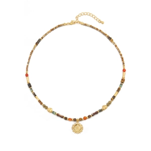 Vintage earth-tone beaded necklace with golden sun pendant on a plain white background