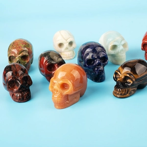 Set of nine natural gemstone skull carvings including tiger eye and lapis lazuli