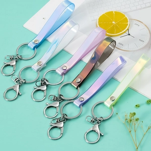 Set of 6 colorful laser PVC keychains with metal lobster clasps on a mint green background