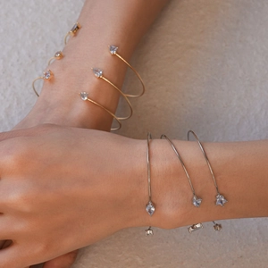 Détails de bracelets joncs en or et argent avec zircons en forme d'étoile et goutte
