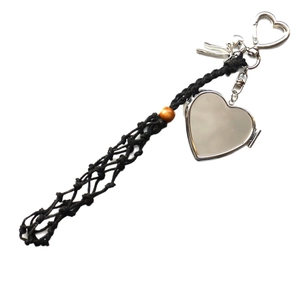 Minimalist silver heart locket bag pendant with woven cord and decorative metal charms