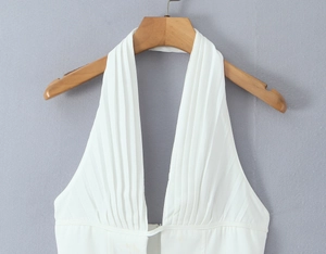 Detail of white deep V-neck halter top with elegant pleated ruffle texture on hanger