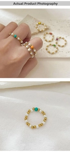 Macro shot of 18K gold bead and freshwater pearl elastic ring with colorful gemstone accent