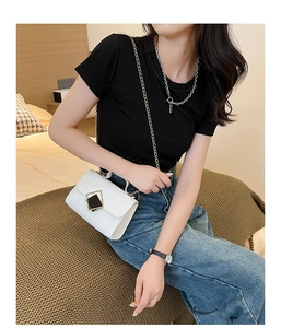 Bolso bandolera blanco con textura tejida, hebilla metálica y correa de cadena en modelo