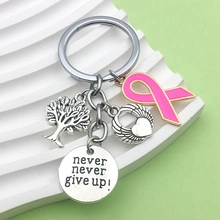 Detailed view of silver gym keychain with tree of life, angel heart and pink ribbon charms