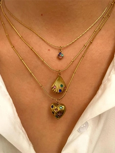 Close-up of layered gold necklace set with colorful shell, heart, and square pendants