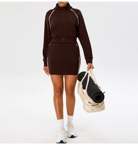 Detail of dark brown athletic two-piece set with white trim and stand-up collar design