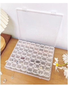 Detailed view of clear acrylic jewelry box with compartments on a wooden table