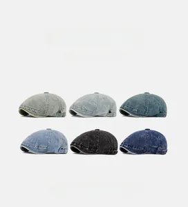 Detail view of six shades of washed denim beret hats with adjustable metal buckles