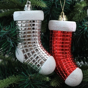 Silver and red checkered Christmas stocking ornaments hanging on green pine branches