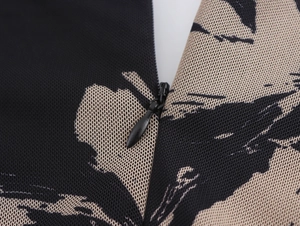 Gros plan détaillé d'une fermeture éclair invisible sur une robe en résille à fleurs noires