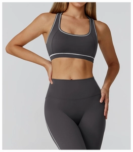 Close-up of contrast stitching on dark grey racerback yoga bra and leggings set