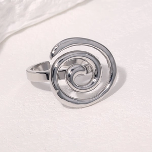 Detailed macro view of silver stainless steel spiral ring on white textured background