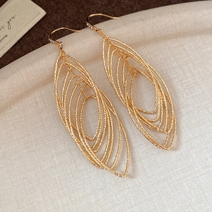 Golden multi-layer hollow oval ear clips with small diamond accents on textured tray