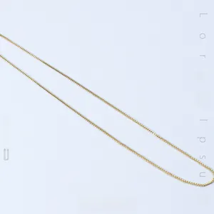 Detailed view of a slender gold-plated titanium snake chain necklace with high polish