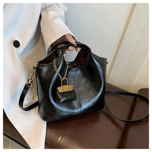 Detailed shot of black vintage oil wax leather tote bag with elegant gold chain accessory