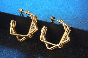 Macro view of gold geometric multilayer hexagonal earrings with a polished metal finish
