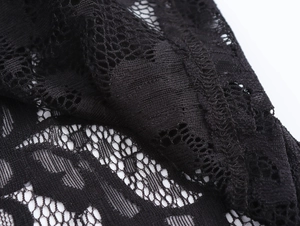 Detailed macro view showing the intricate floral lace patterns and texture of the black dress