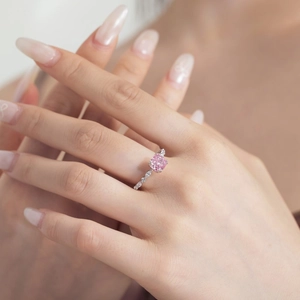 Detailed macro of a square pink zircon silver ring worn on a finger with side diamonds