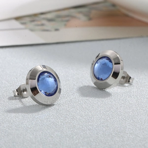 Macro shot of silver stud earrings featuring faceted blue crystals with elegant settings
