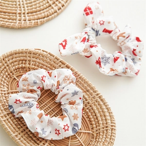 Detail of Christmas scrunchies with gingerbread man and snowflake patterns on white fabric