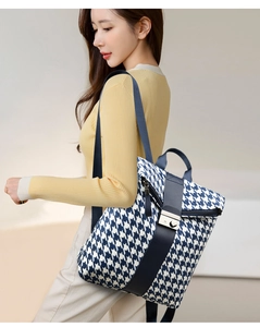 Detail eines blau-weißen Rucksacks mit Hahnentrittmuster und dunkelblauem Riemen