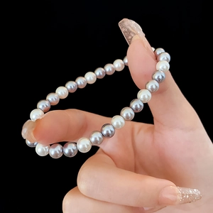 Close-up of grey and white pearl bracelet on wrist with elegant polished luster