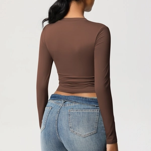 Vue détaillée du dos d'un crop top de sport marron ajusté à manches longues
