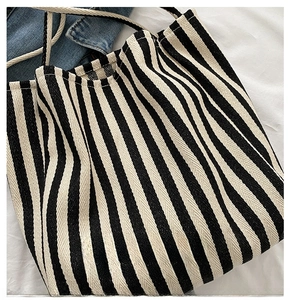 Detail of black and white striped canvas tote with braided rope handle and woven texture