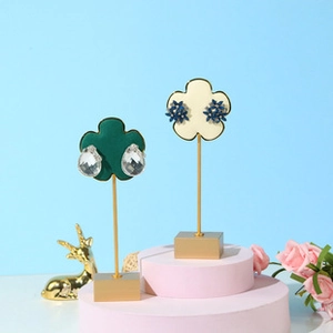 Macro detail of petal-shaped velvet earring stands with gold metal base display set