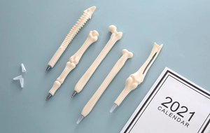 Detail view of five novelty bone-shaped ballpoint pens with realistic bone textures