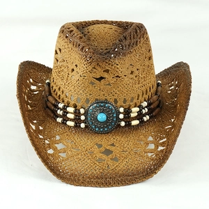 Dettaglio di cappello da cowboy in paglia con perline etniche e centro in turchese